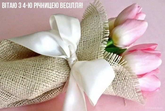 Роза квітів у білому стрічці для привітання з річникою весілля.