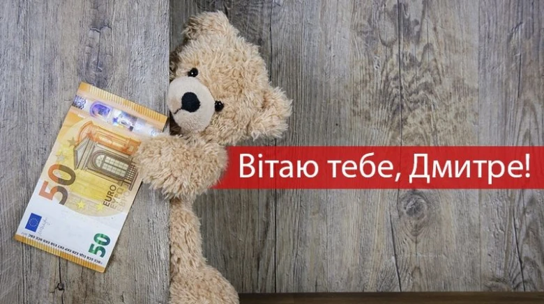 Мішка тримає купюру, вітаючи Дмитра з днем ангела.