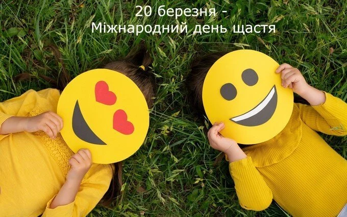 Діти з емодзі-обличчями на траві для свята щастя.