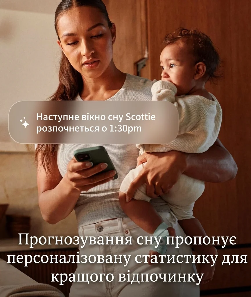 Мати тримає дитину і дивиться на сповіщення про сон