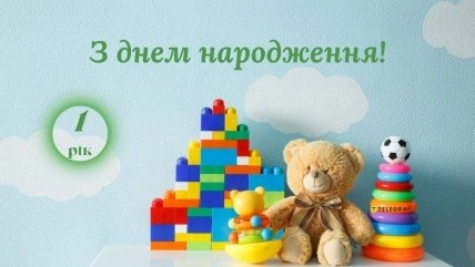 Кольорові іграшки та напис з привітанням на перший день народження.