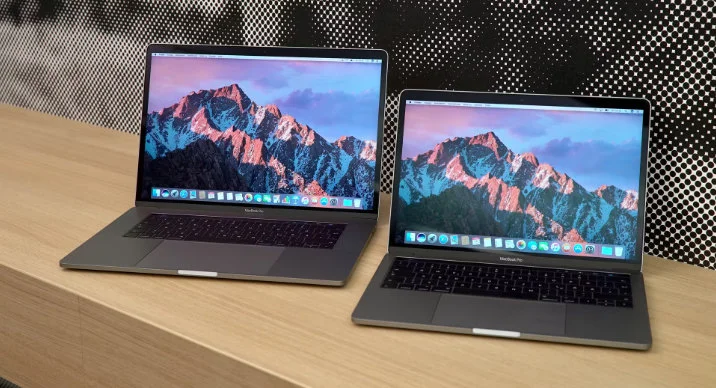 Два відкриті ноутбуки Mac на дерев'яній поверхні