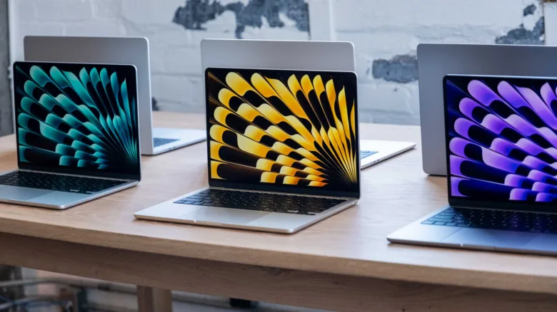 Три ноутбуки Apple на дерев'яному столі для статті про вибір.