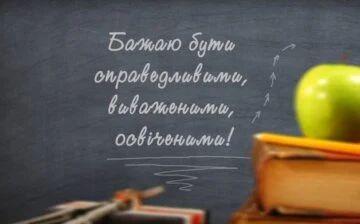 Чорна дошка з привітанням та яблуком на початок навчального року.