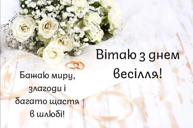 Білі квіти та золоті кільця на білому фоні з привітанням.