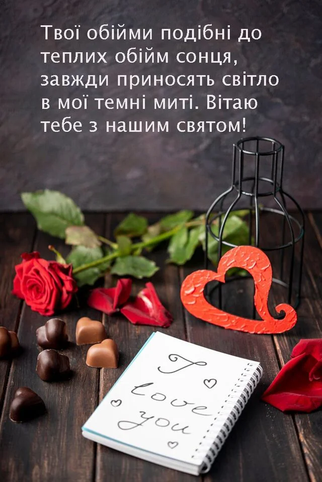 Квіти, шоколад та напис 'Я тебе кохаю' на дереві.
