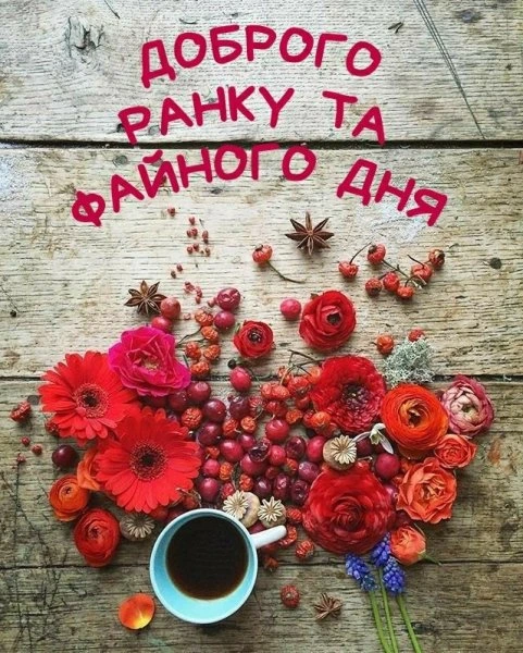 Червоні квіти та кава на дерев'яному фоні з українським привітанням.